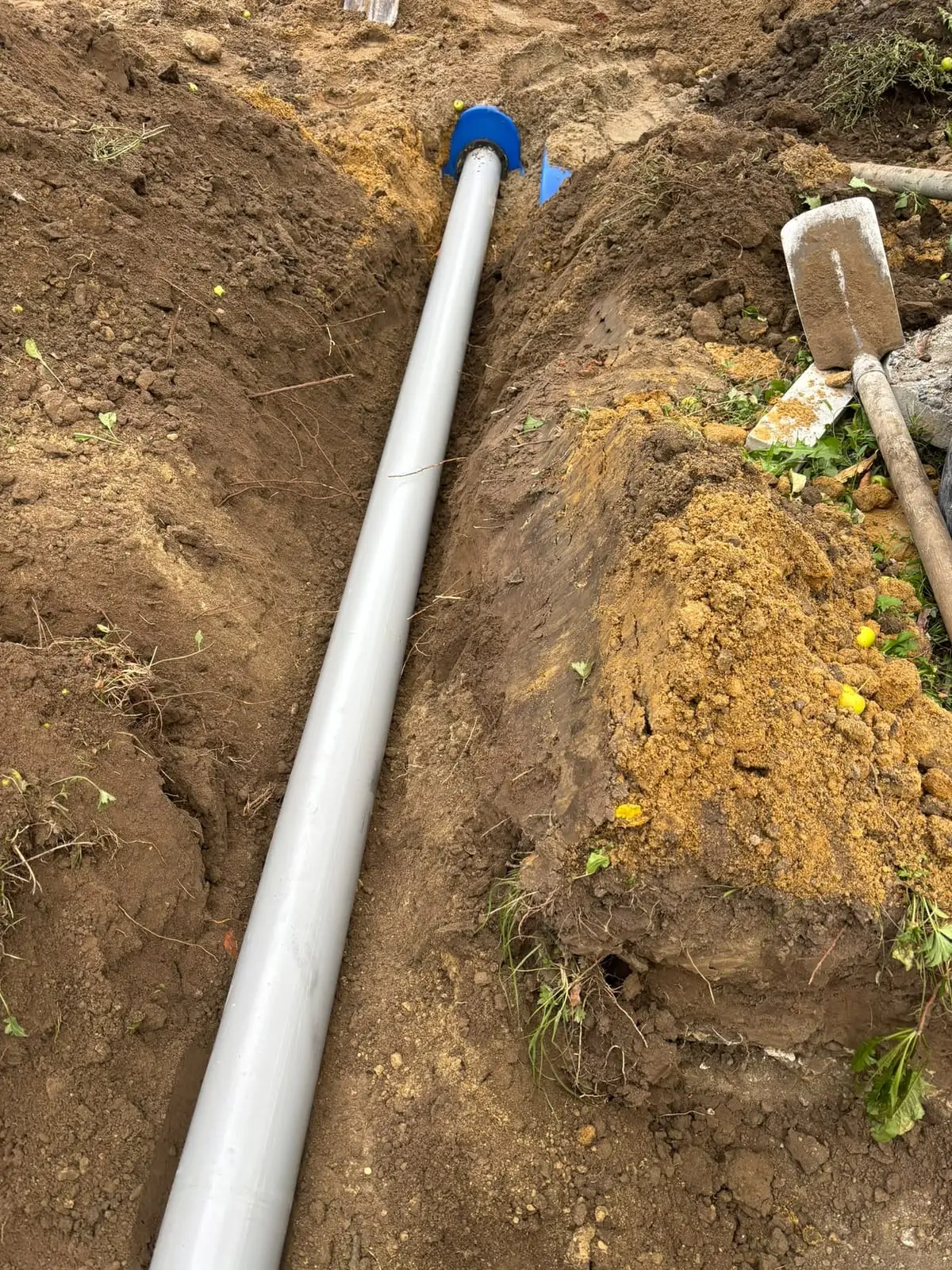 Nieuwe pvc-afvoerleiding in de sleuf in Mariakerke