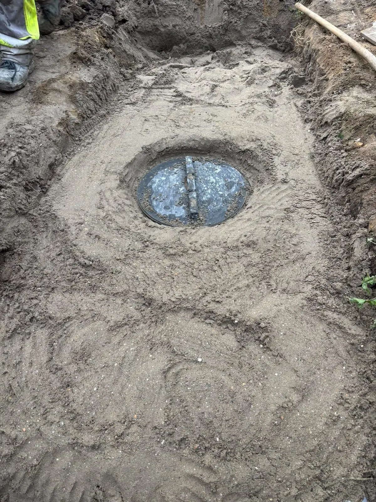 Deksel van de septische put na het aanvullen met zand in Oostakker